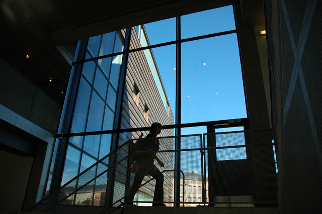 A student walking up the staircase in Rapson Hall.