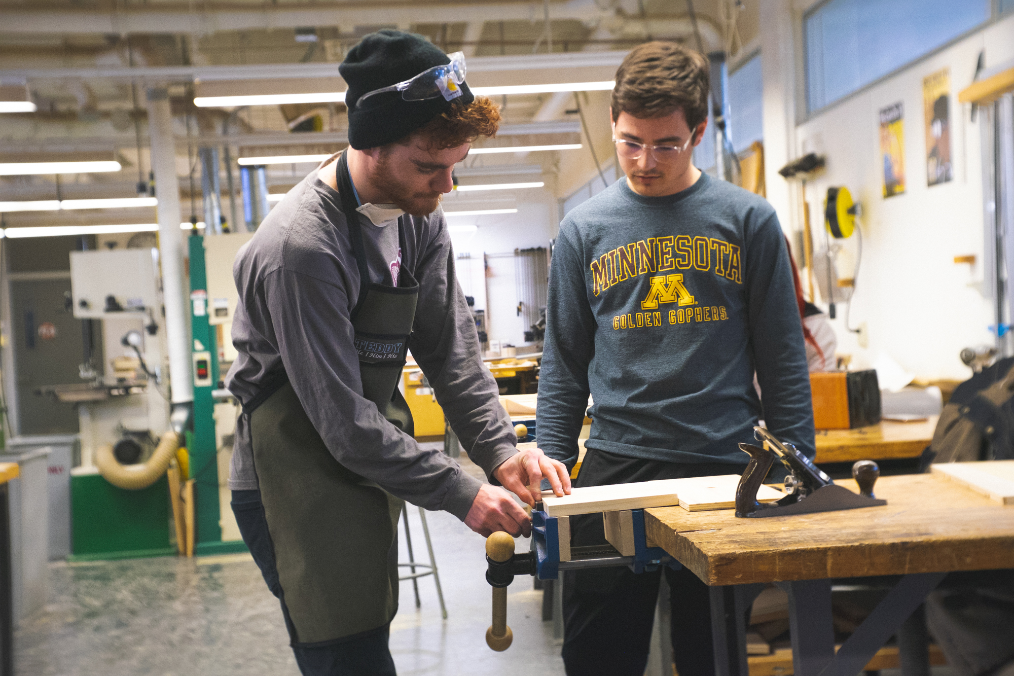 Two students working with wood in the fabrication shop