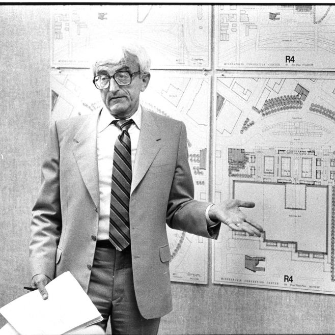 Leonard Parker standing in front of architectural drawings