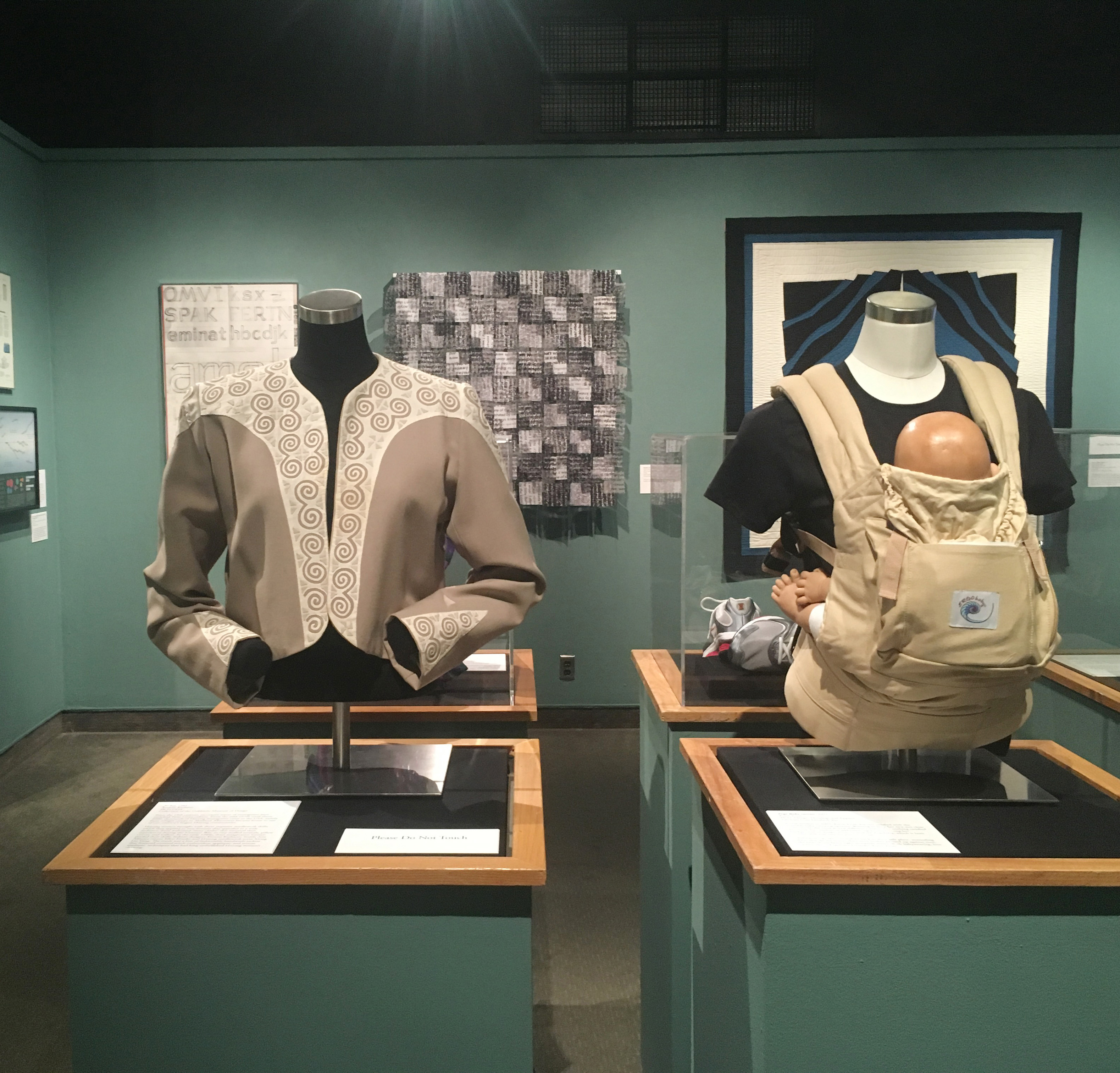 DHA 100 years of graduate education exhibition clothing and artwork on display in gallery
