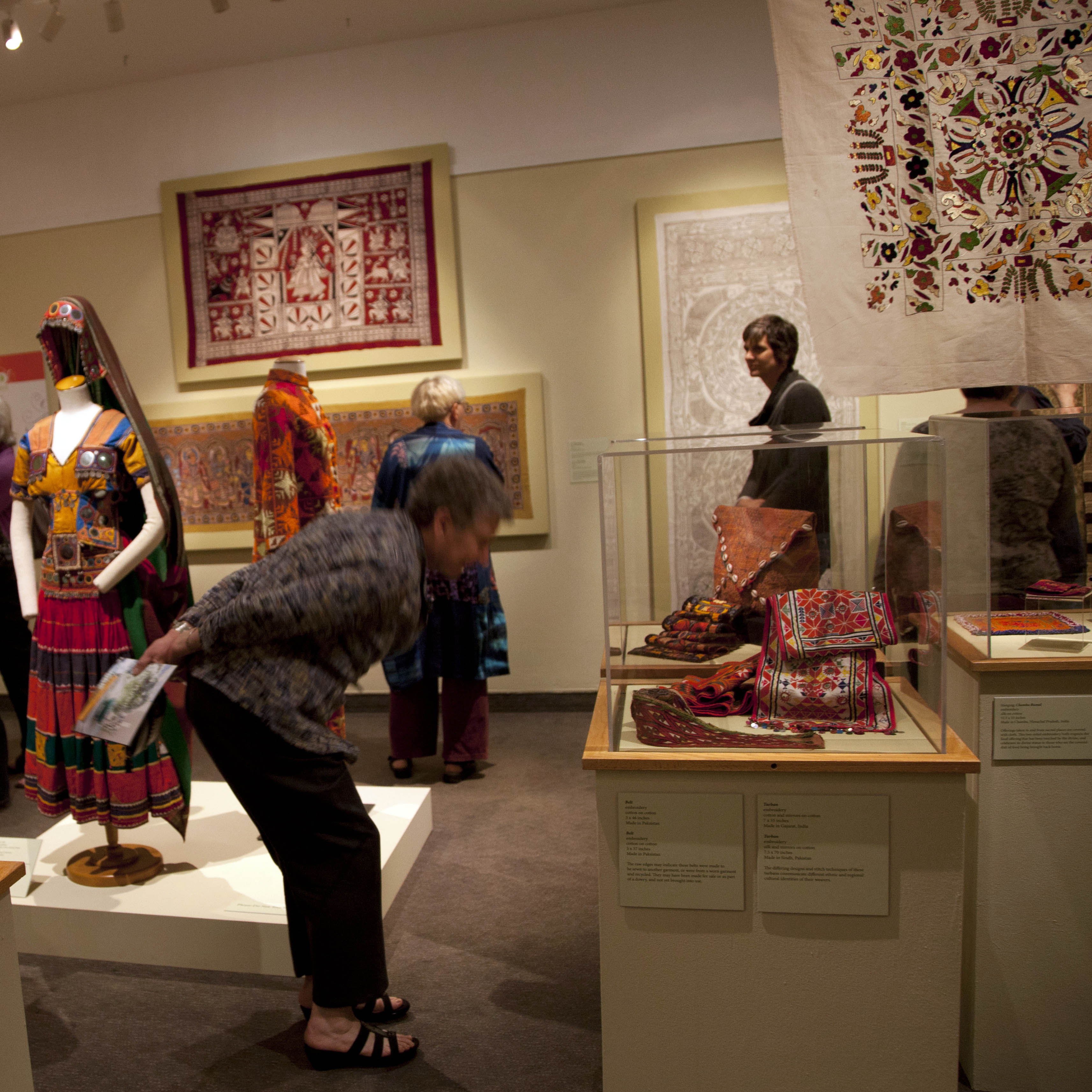 Beyond Peacocks and Paisleys: Handcrafted textiles of India and its neighbors exhibition opening with textiles on view and people milling about