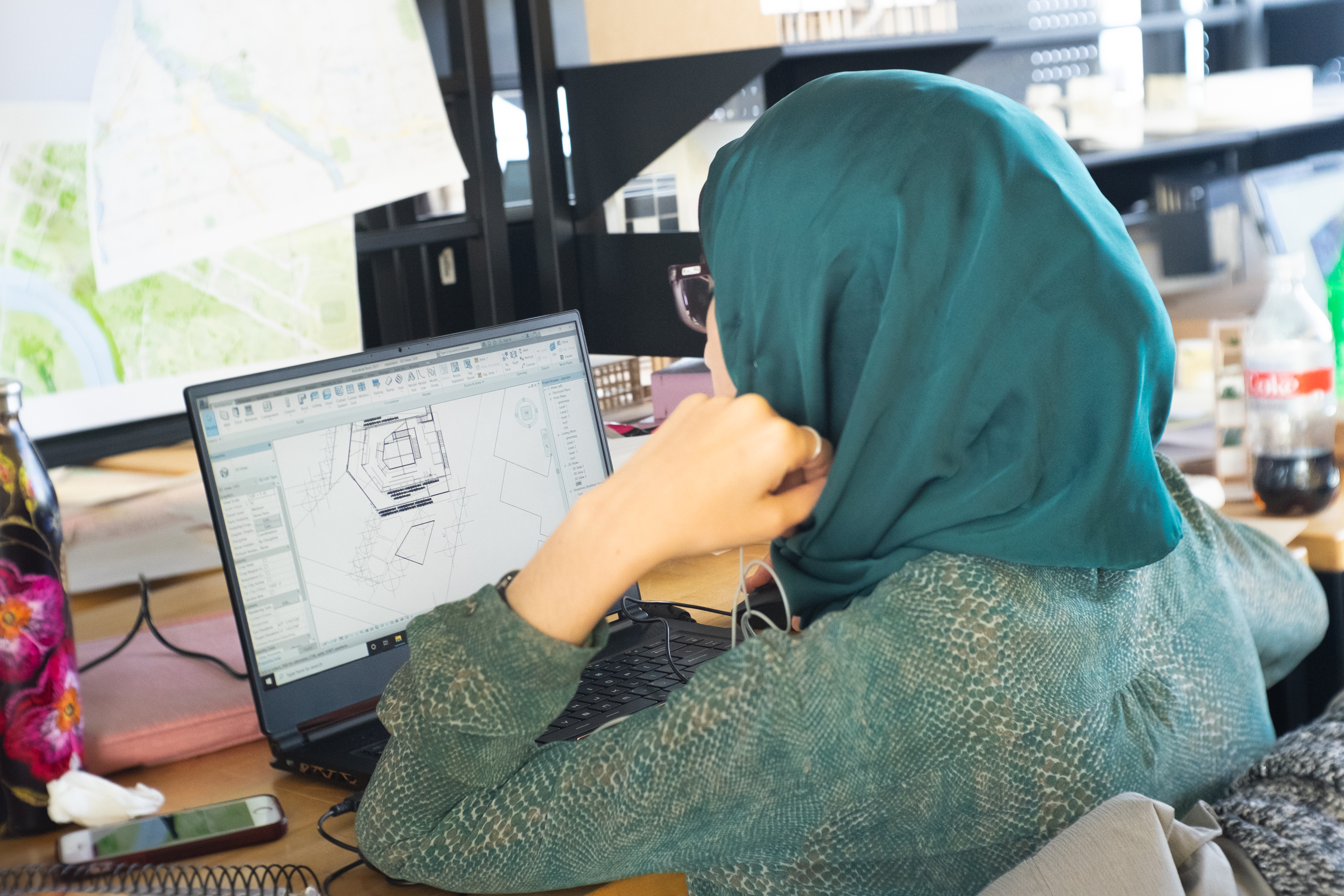 Student working on an architecture project on her computer in the studio space