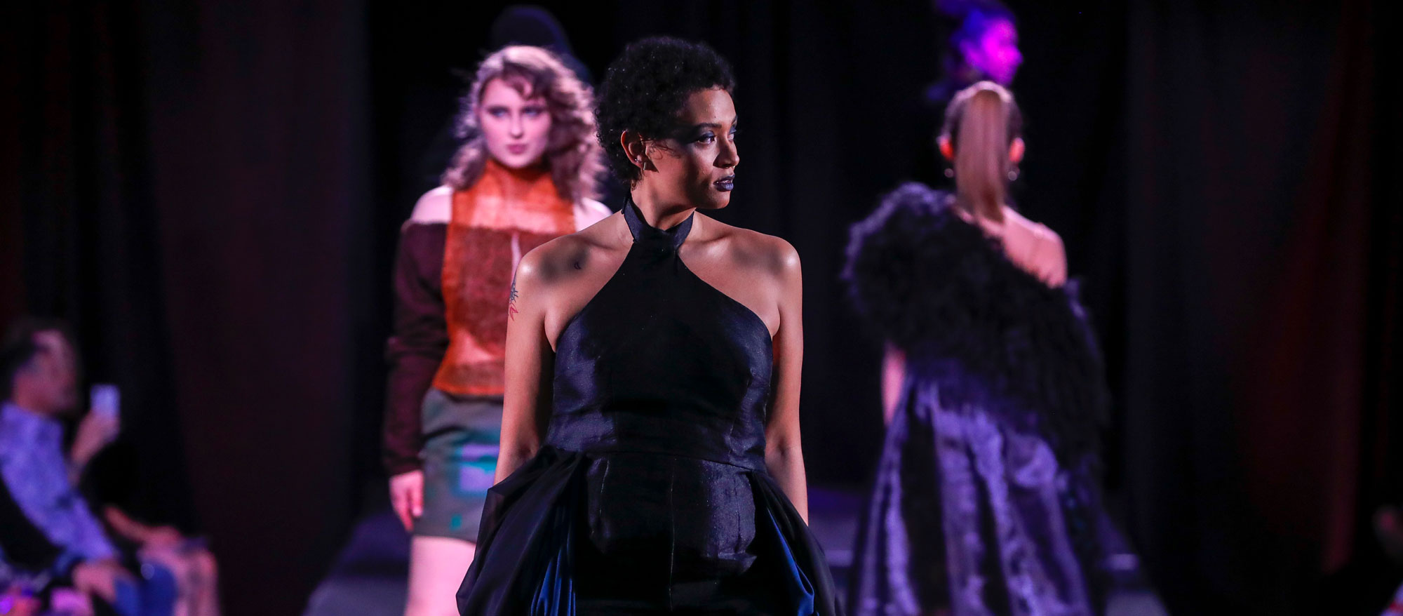 Students wearing fashions designed by apparel students walking the runway at the Apparel Design senior fashion show