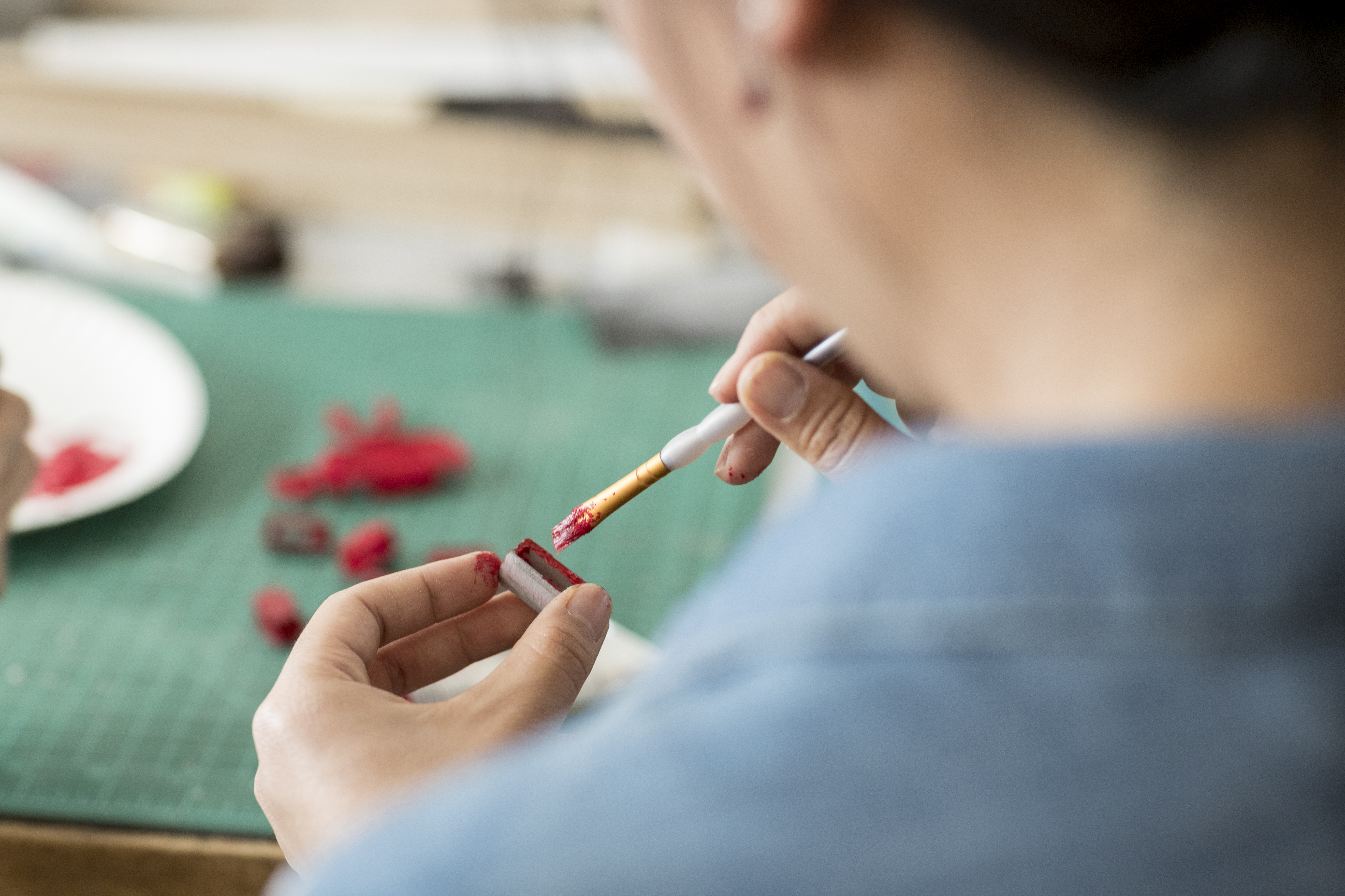 A closeup of a student painting architecture model parts.