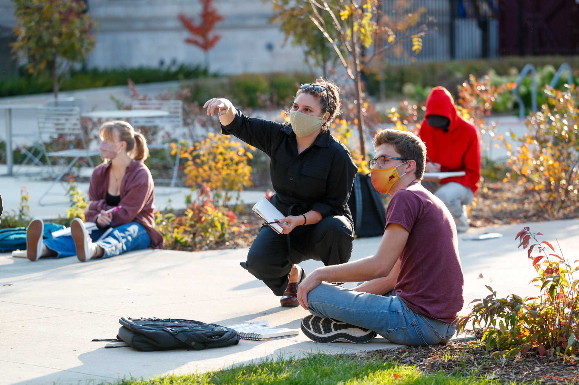 Masked students and faculty in an outdoor drawing class.