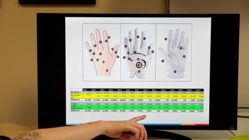 A computer monitor displaying graphics of a hand and a chart of measurements