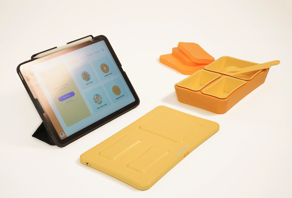 A tablet, digital scale, and plastic dish used to measure users food intake.