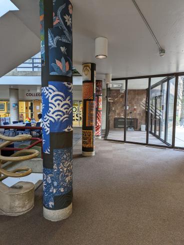 Three pillars wrapped in different fabric murals.
